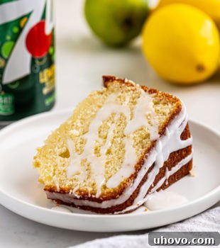 A delectable slice of 7UP cake on a pristine white plate, showcasing its golden crumb and delicate glaze.