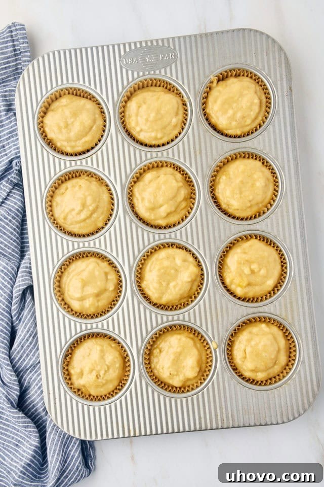 overhead view of banana bread batter portioned in a 12-cup muffin pan