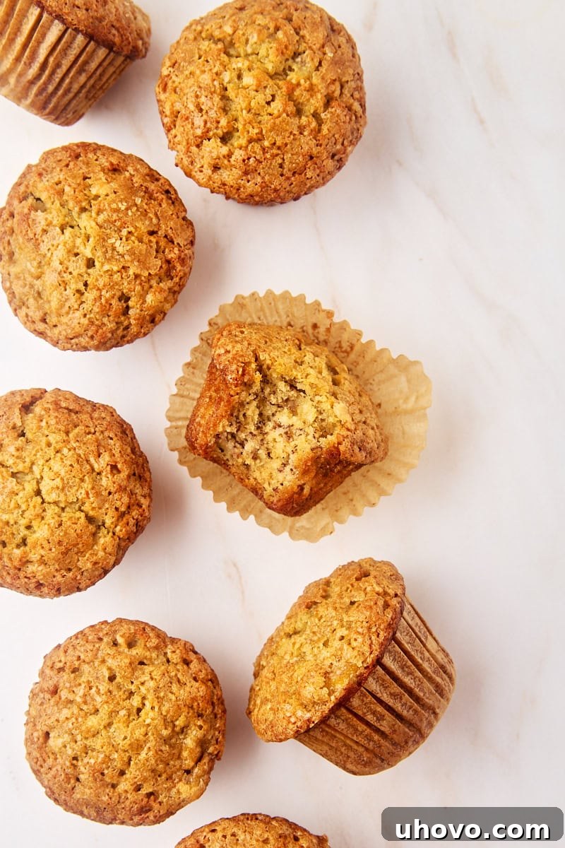 overhead view of several banana muffins, with a bite missing from one of them