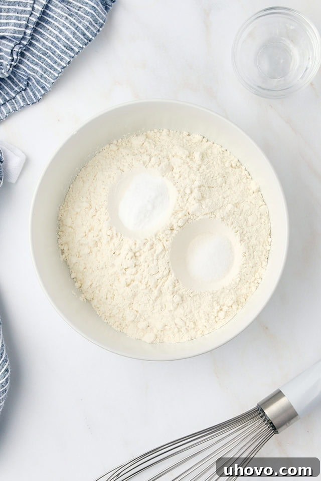 overhead view of flour, baking soda, and salt in a white bowl
