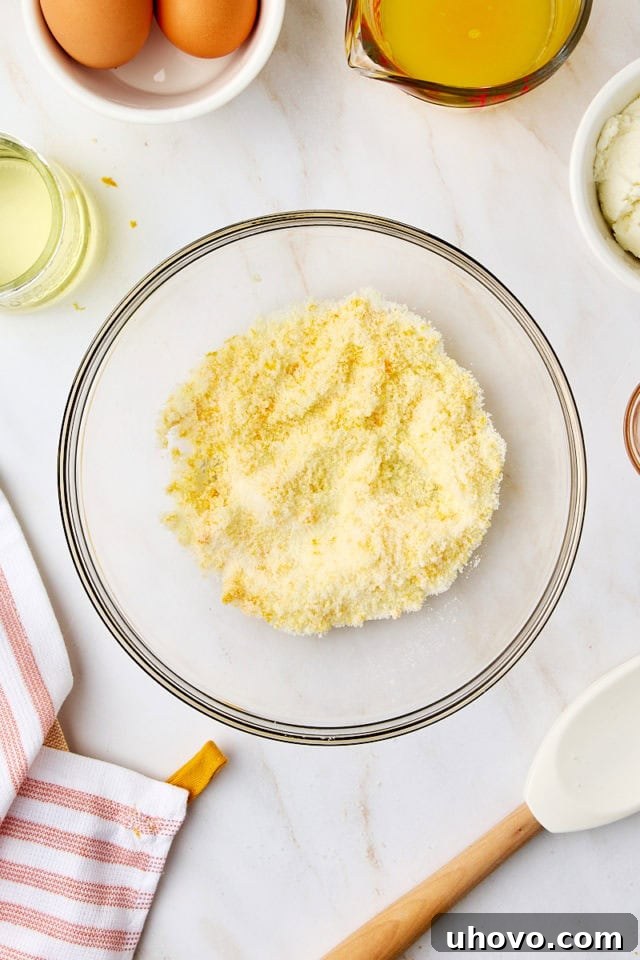 Overhead view of fragrant orange zest thoroughly mixed with sugar, showing a slightly clumpy, aromatic mixture after rubbing