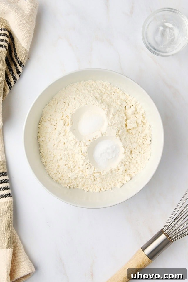 overhead view of flour, baking soda, and salt in a white bowl