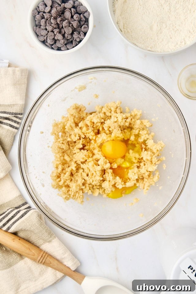 overhead view of egg added to creamed butter and sugar