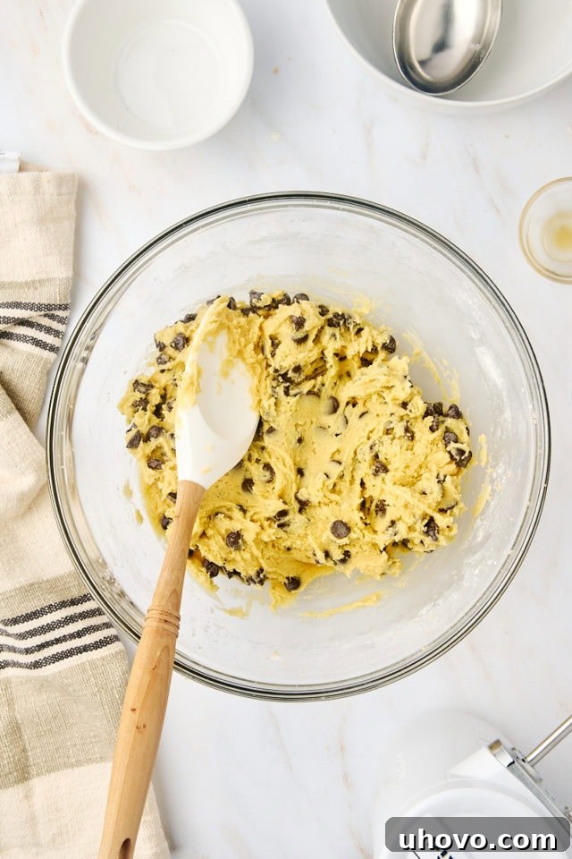 overhead view of chocolate chip cookie dough in a glass mixing bowl