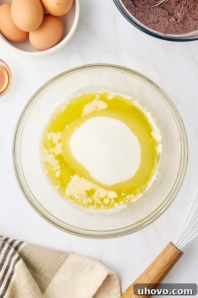overhead view of melted butter and sugar in a glass mixing bowl