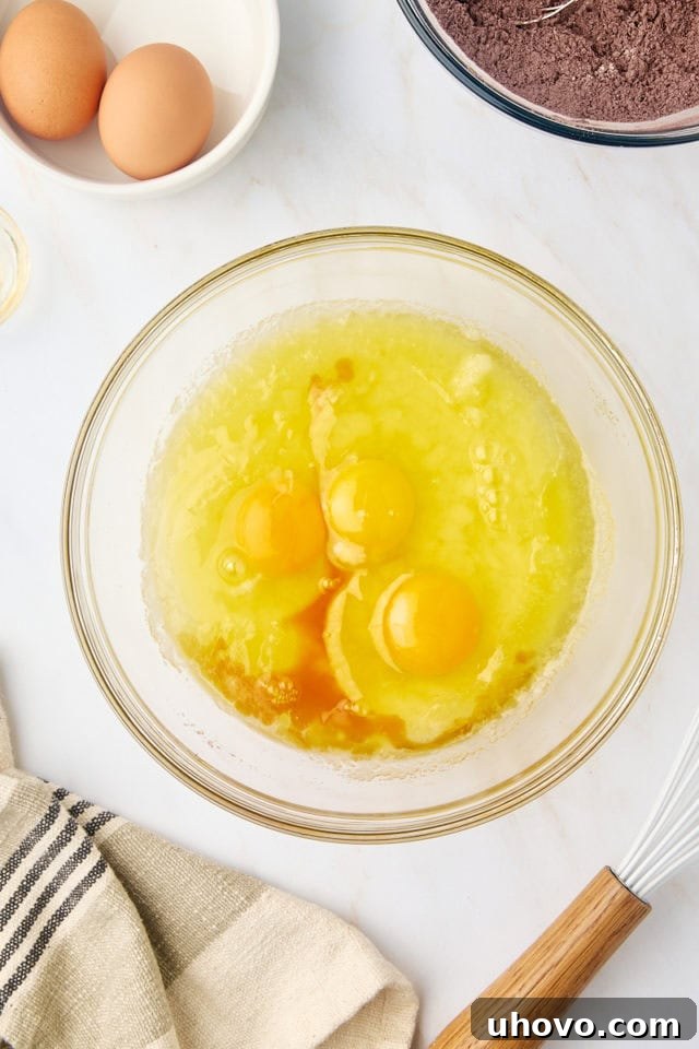 overhead view of eggs and vanilla added to melted butter and sugar mixture