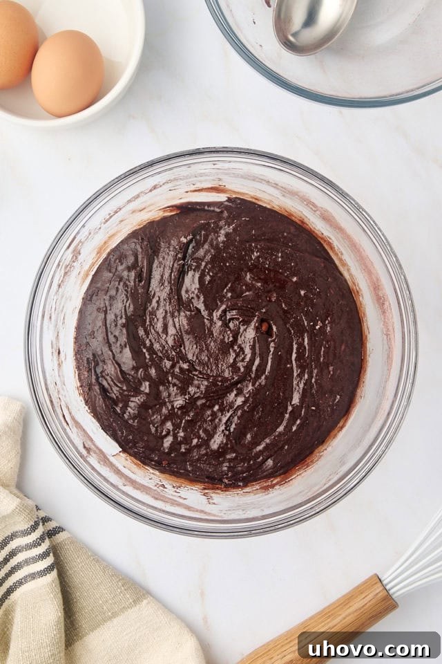 overhead view of brownie batter in a glass mixing bowl