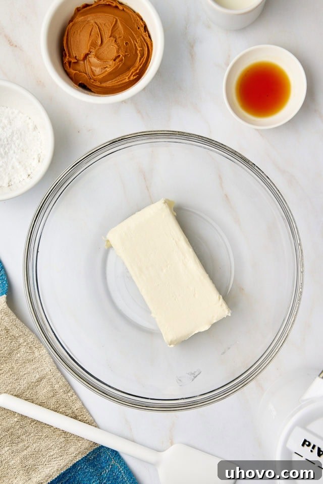 overhead view of cream cheese in a glass mixing bowl