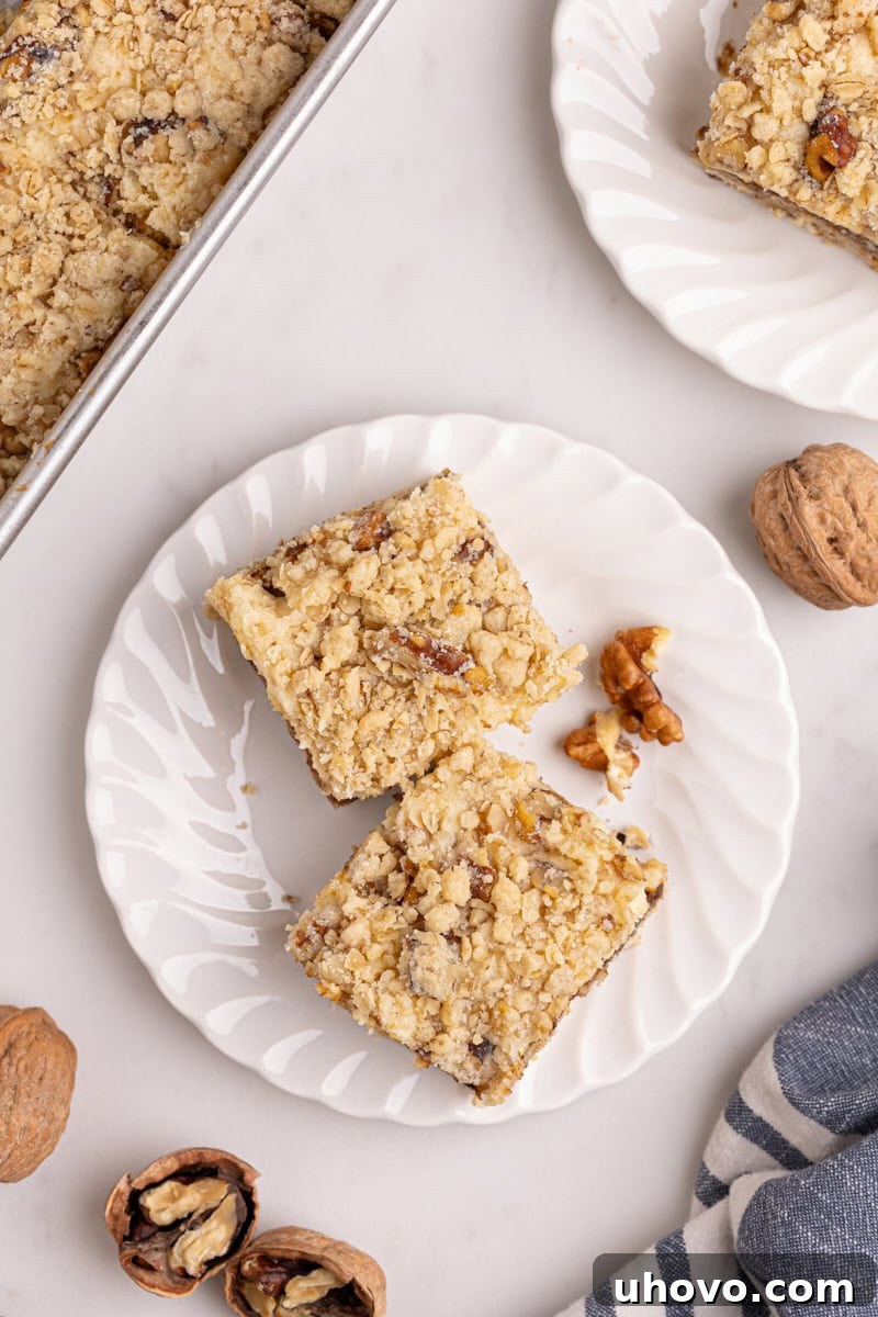 apple butter cream cheese oat bars on a white plate with more bars surrounding