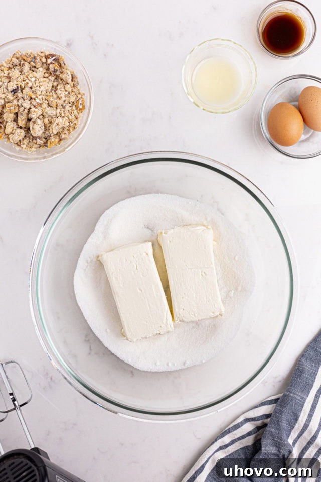 overhead view of cream cheese and sugar in a glass mixing bowl
