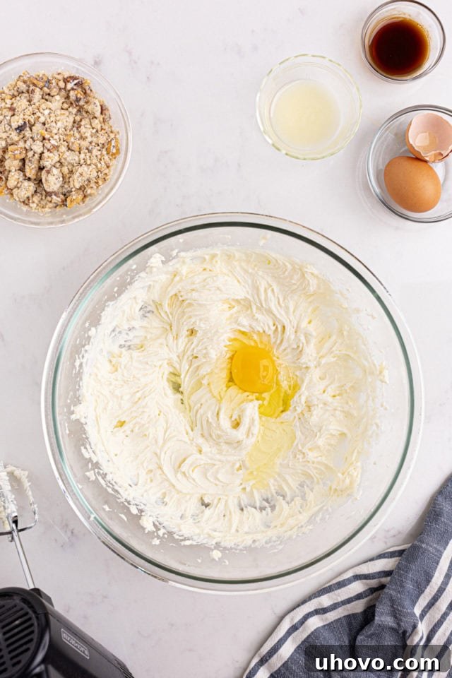 overhead view of egg added to cheesecake mixture