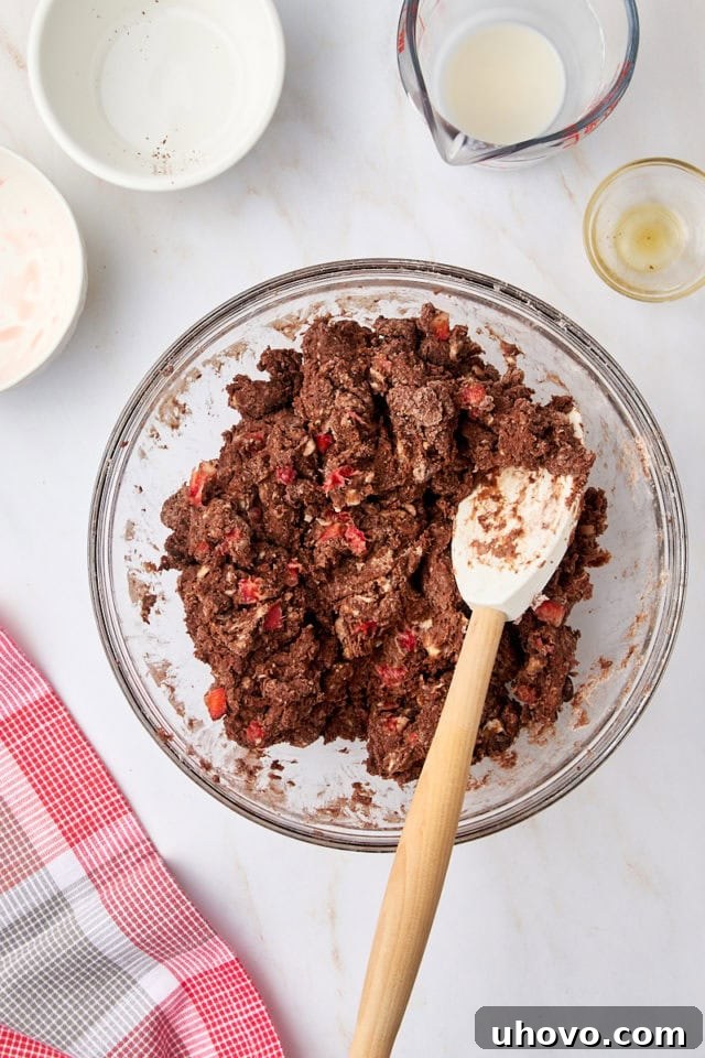 Overhead view of the chocolate strawberry scone dough in a glass mixing bowl, just combined.