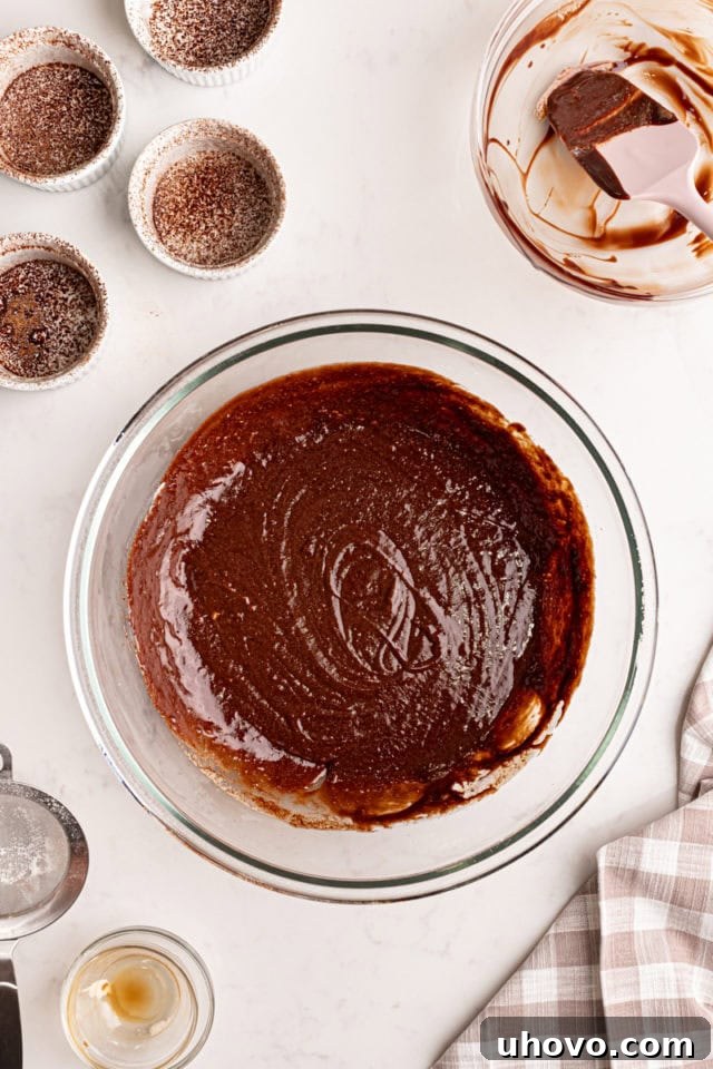 An overhead shot of the fully mixed chocolate lava cake batter in a glass bowl, showcasing its smooth, glossy, and uniform consistency, ready for baking.