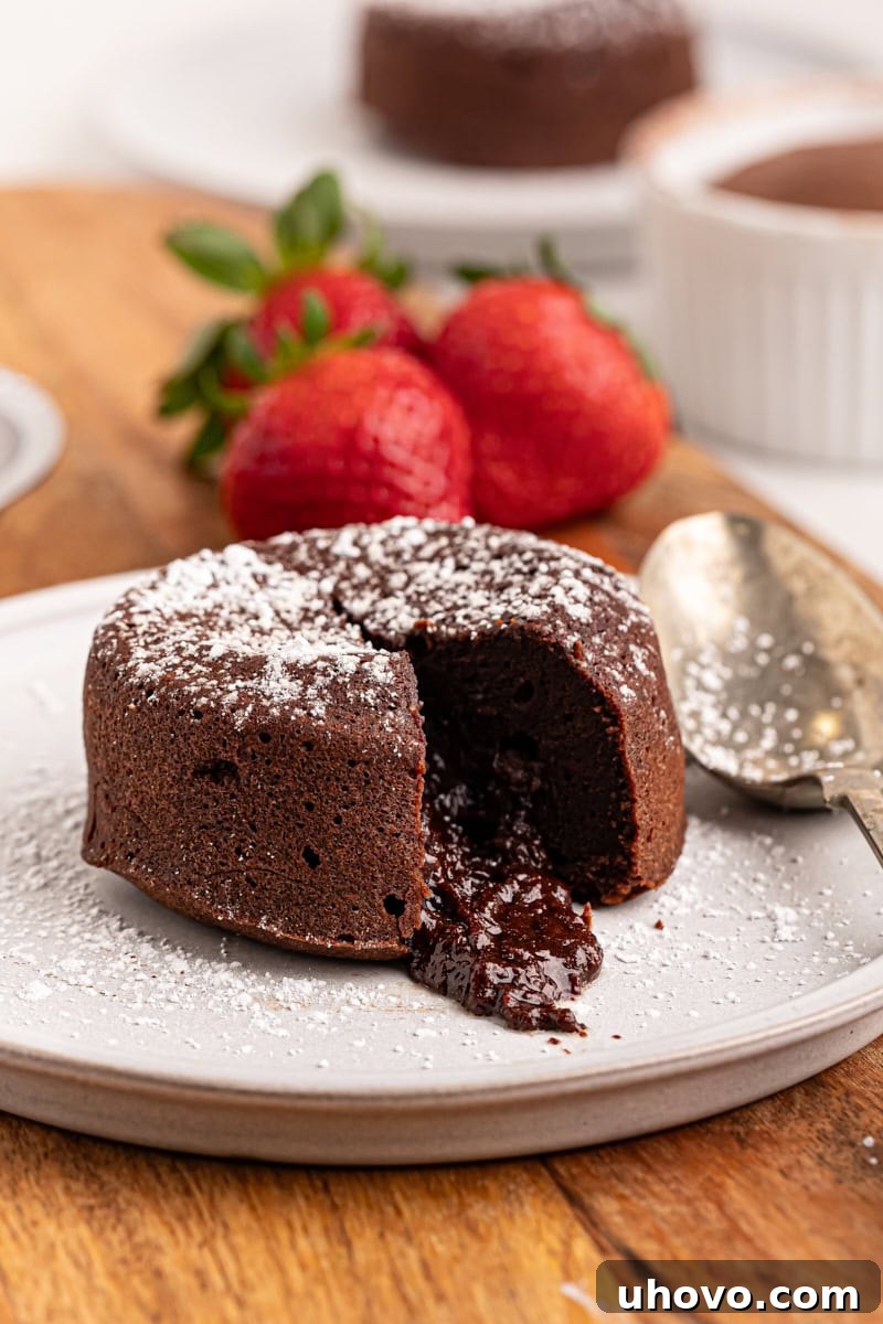 A close-up of a chocolate lava cake on a white plate, with the rich, molten chocolate center beautifully spilling out, highlighting its decadent allure.