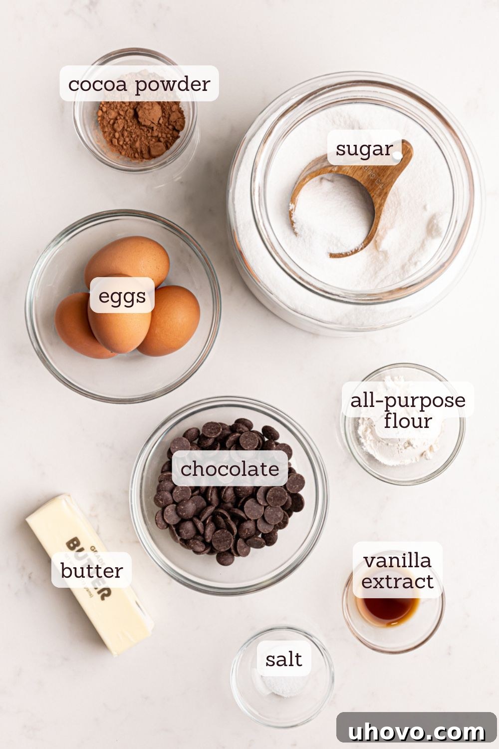 An overhead shot showcasing the neatly arranged ingredients for a chocolate lava cake recipe, including dark chocolate, butter, eggs, sugar, flour, and vanilla extract, ready for preparation.