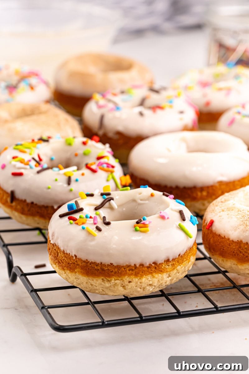 Golden-brown baked doughnuts cooling on a wire rack, ready to be glazed or topped.