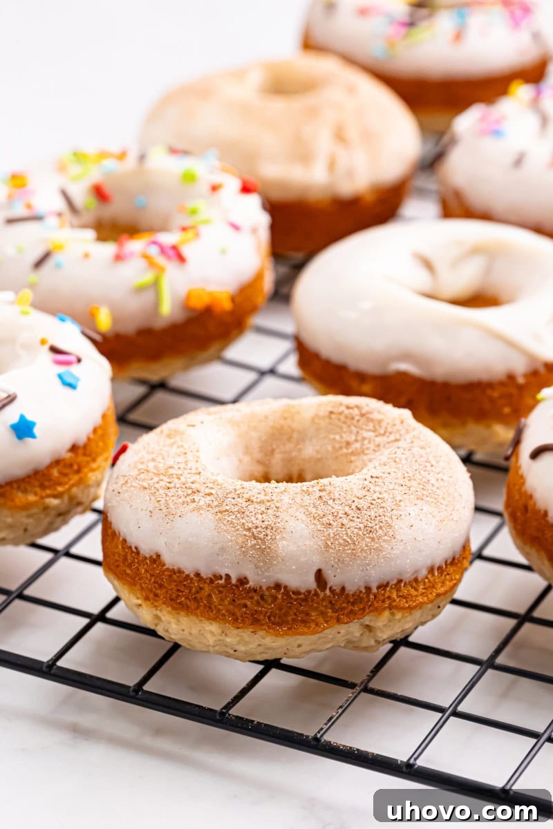 Freshly baked doughnuts arranged neatly on a wire rack, glistening with a light glaze.