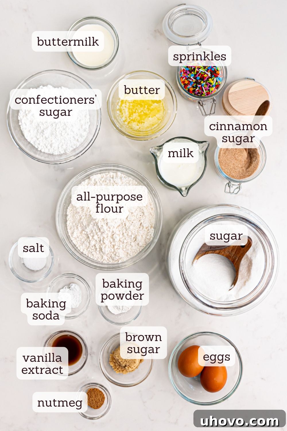 Overhead shot of carefully measured ingredients for baked doughnuts laid out on a clean surface.