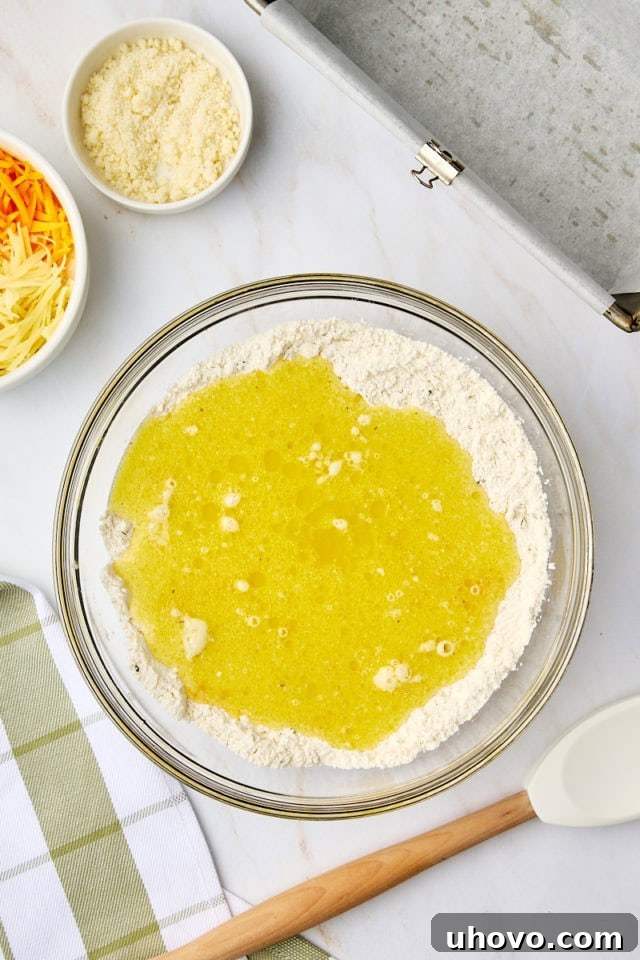 overhead view of wet ingredients added to dry ingredients for herb and cheese quick bread