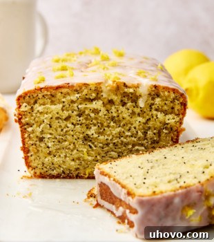 A cross-section of a lemon poppy seed loaf, revealing its soft, moist, and seed-filled inside, ready to be enjoyed.