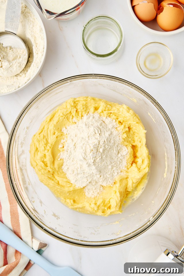 The process of adding dry ingredients to wet ingredients, alternating with buttermilk, to form the yellow cake batter.