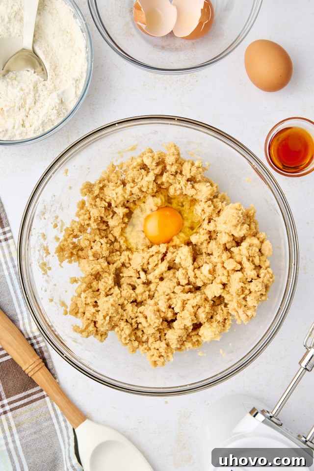 overhead view of egg added to creamed butter and brown sugar