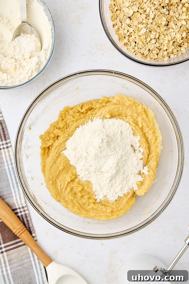 overhead view of flour mixture added to butter mixture for revel bars