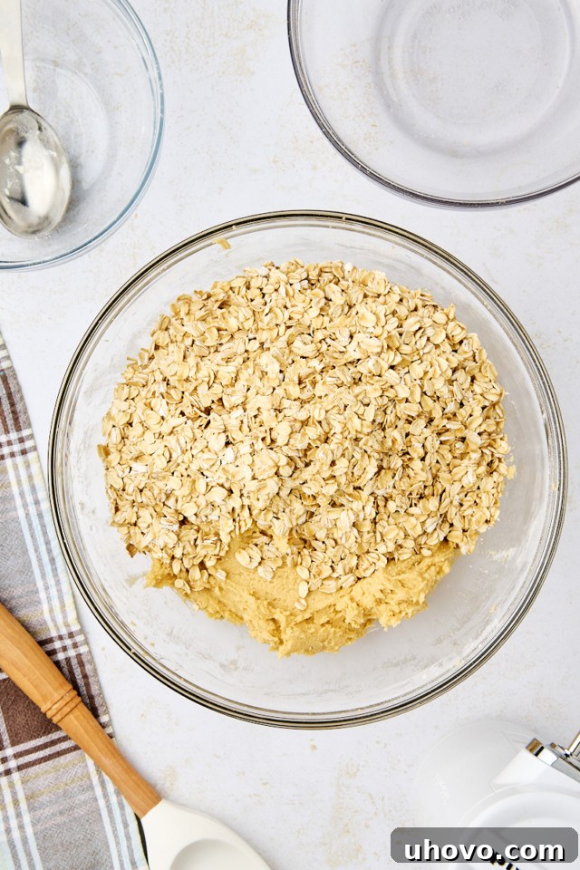 overhead view of oats added to revel bars dough