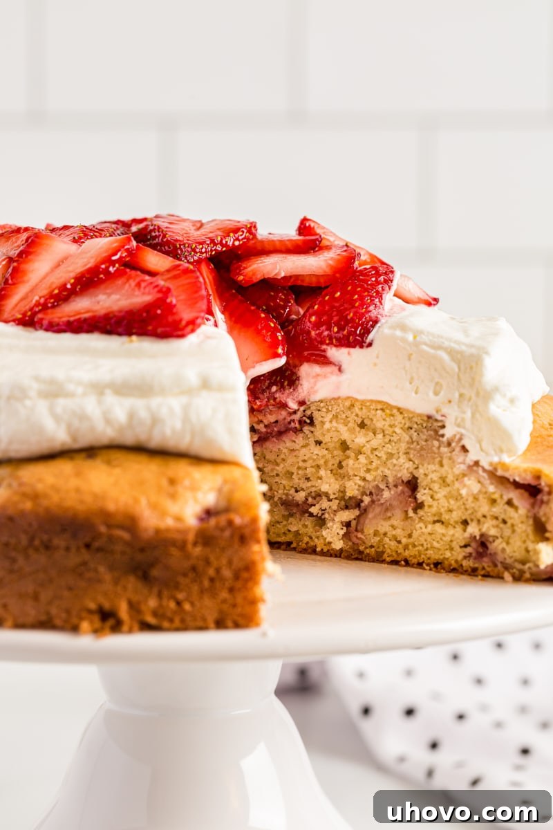 Lemon-Strawberry Shortcake on a cake stand with one slice removed, ready to be enjoyed.