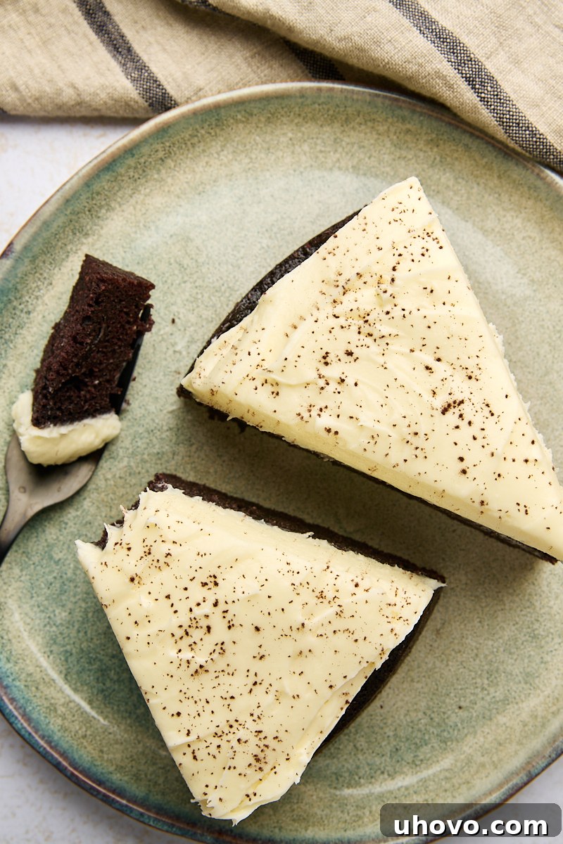 Overhead view of two generous slices of Guinness chocolate cake on a vibrant green plate, with a fork holding a bite, emphasizing the celebratory aspect.