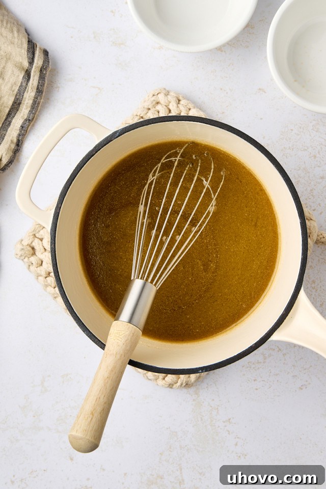 Overhead view of melted butter, Guinness, granulated sugar, and brown sugar mixed together in a saucepan until dissolved.