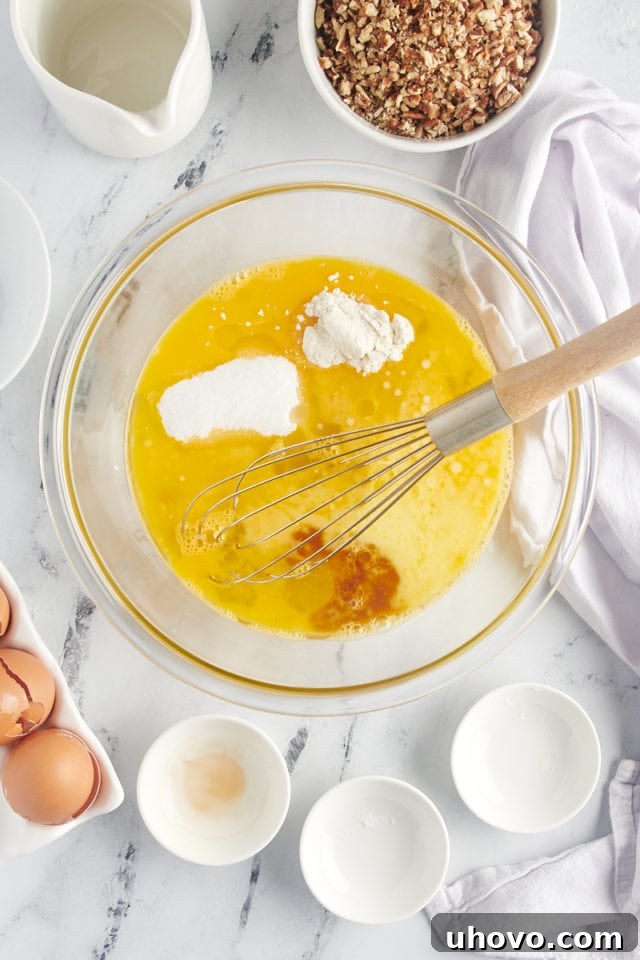A bowl containing whisked eggs, with granulated sugar, corn syrup, melted butter, and all-purpose flour being added, ready for mixing to create the pecan pie filling.
