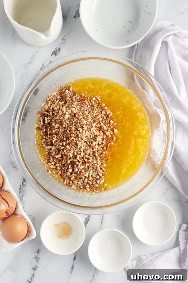 Chopped pecans being added to the rich, golden egg-based mixture for the pecan pie filling, ready for final mixing.