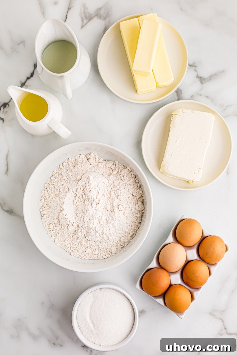 An organized overhead display of all the fresh ingredients needed to bake Lemon Chess Tartlets, including lemons, butter, flour, and eggs.