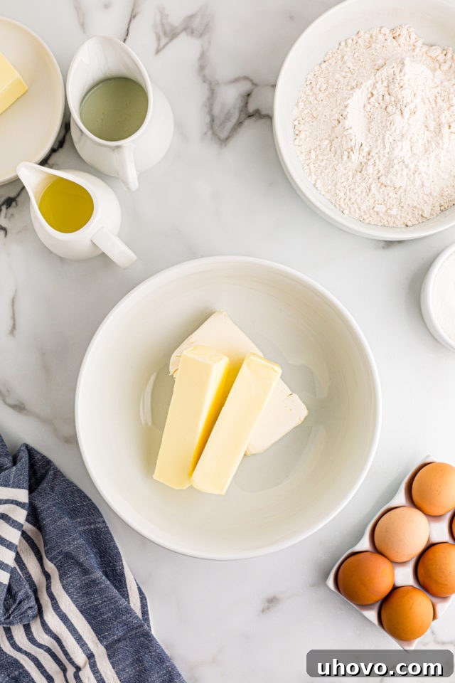A pristine white mixing bowl holds softened butter and cream cheese, ready to be creamed for the tartlet crust.