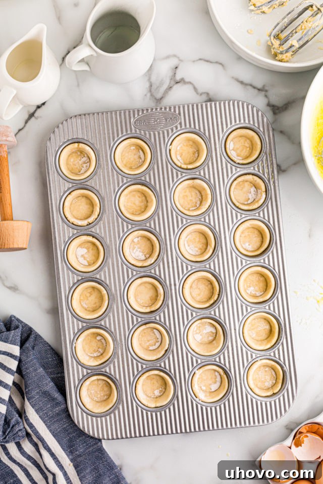 Mini muffin pan with perfectly formed pie crusts lining each cup, ready to be filled.