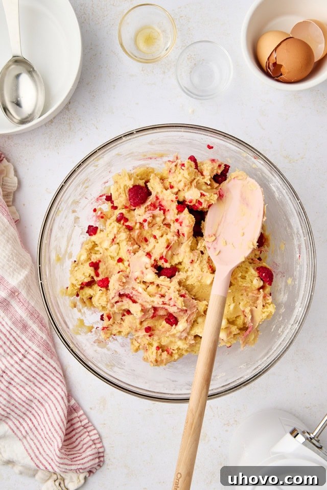 overhead view of raspberry white chocolate cookie dough in a glass mixing bowl