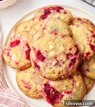 overhead view of raspberry white chocolate cookies piled on a white plate