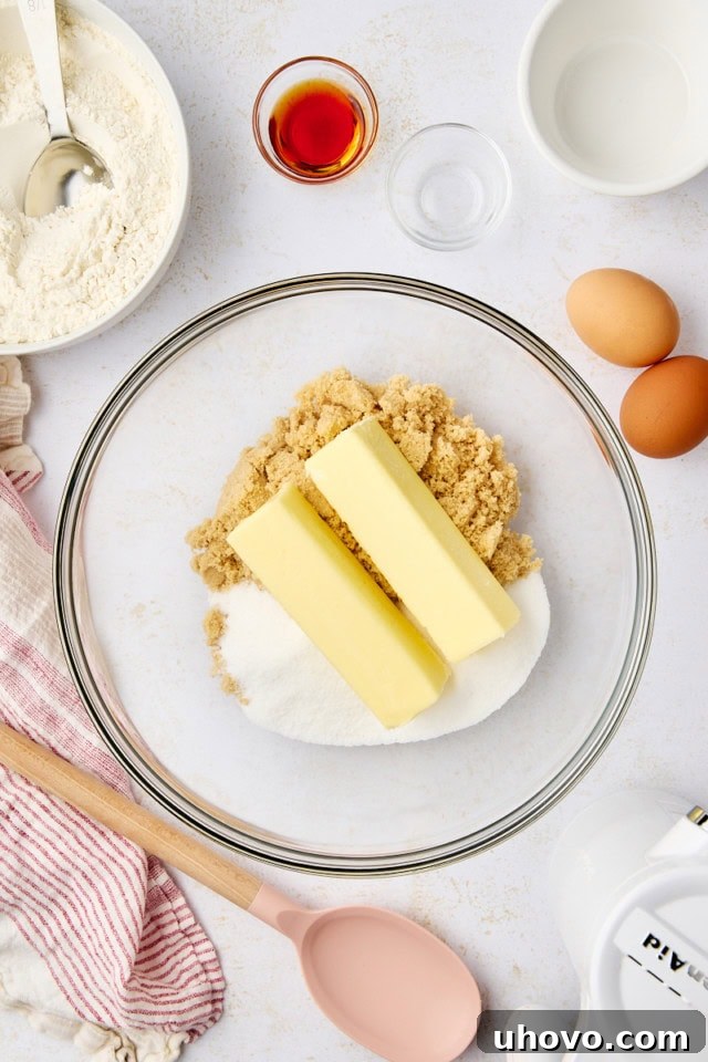 overhead view of butter, sugar, and brown sugar in a glass mixing bowl