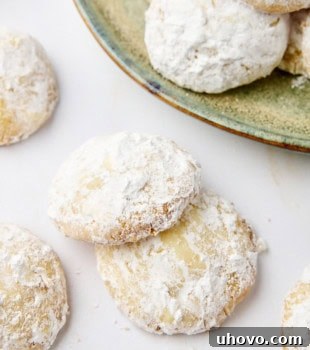 Lemon cooler cookies scattered on a white countertop and neatly arranged on a green plate, highlighting their delightful appearance.