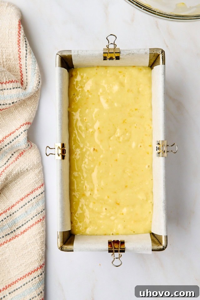 An overhead view of the yogurt cake batter smoothly transferred into a metal loaf pan, ready to go into the oven for baking, promising a golden, delicious outcome.
