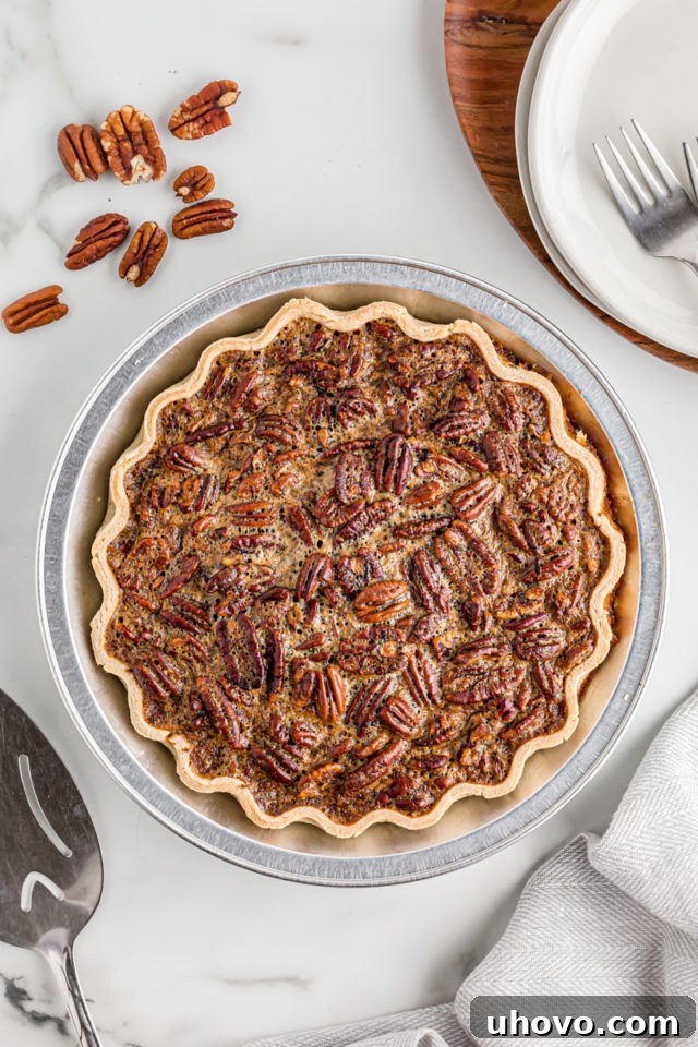 Overhead view of a perfectly baked whole pecan pie, showing its golden-brown crust and glistening, set filling.