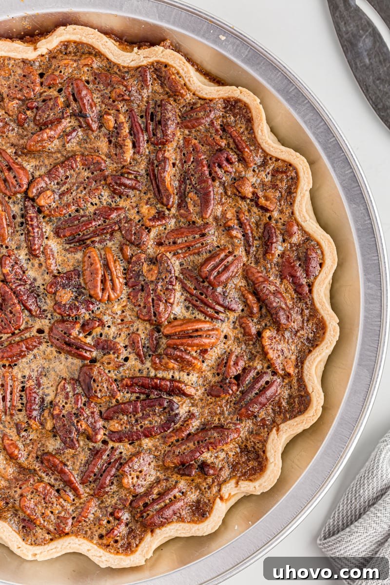 An inviting overhead view of a freshly baked, golden-brown whole pecan pie, cooled and ready to be sliced.