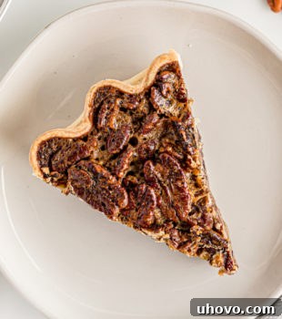 Overhead view of a perfect slice of classic pecan pie on a plate, ready to be enjoyed.