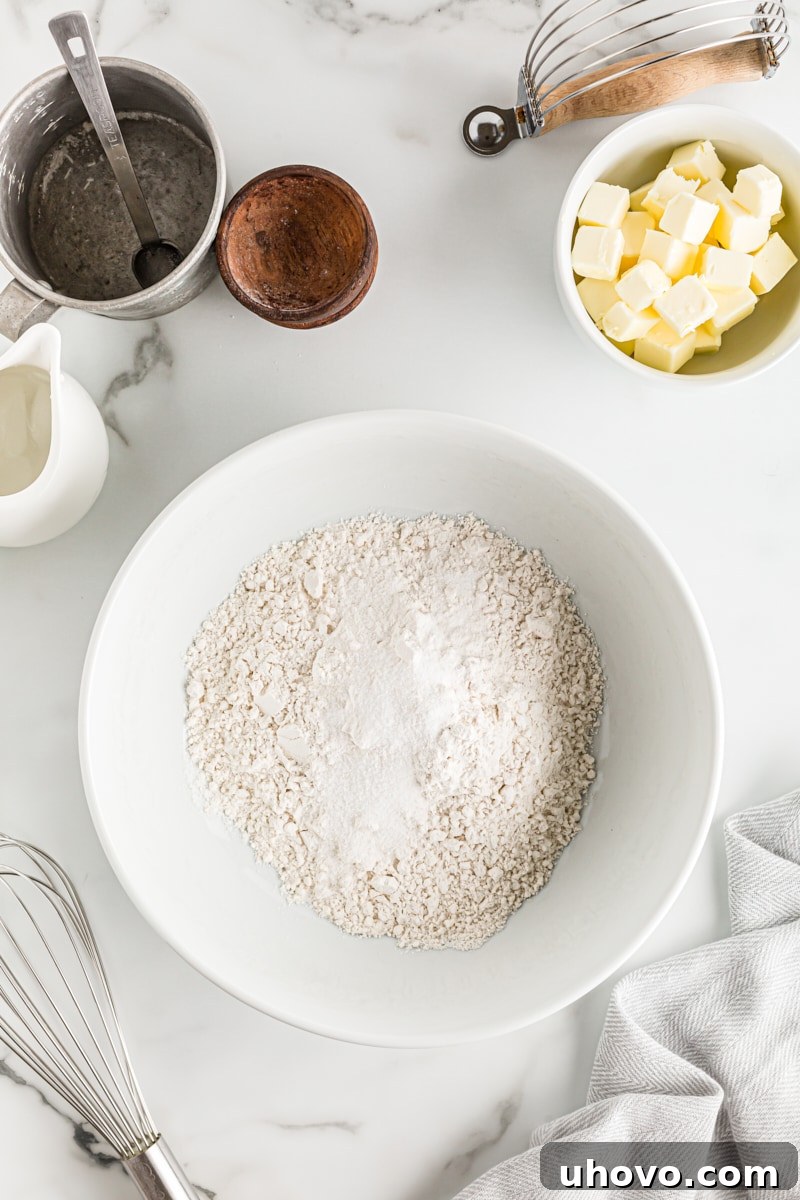 Overhead view of dry pie crust ingredients in a mixing bowl: all-purpose flour, granulated sugar, and salt are perfectly combined.