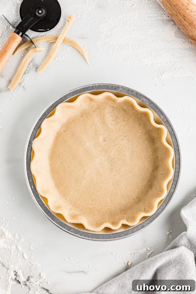 A homemade pie crust carefully placed and crimped within a 9-inch pie plate, ready for filling.