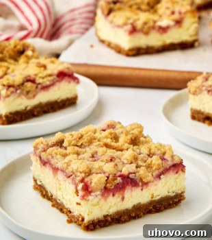 A beautifully presented strawberry cheesecake bar on a white plate, with more bars visible in the background, ready to be enjoyed.