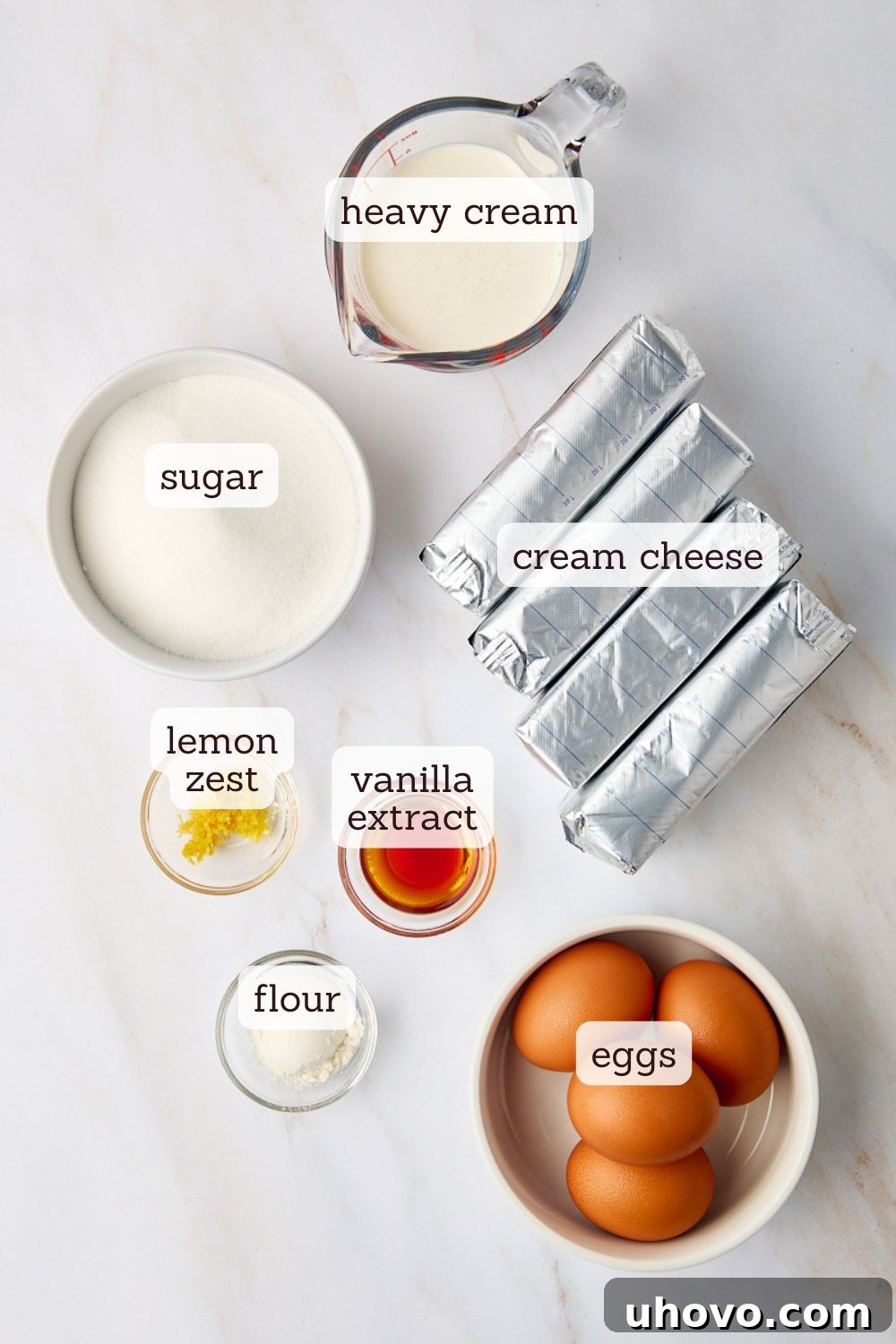 An overhead view captures all the essential ingredients artfully arranged for creating a perfect New York cheesecake, highlighting their freshness and quality.