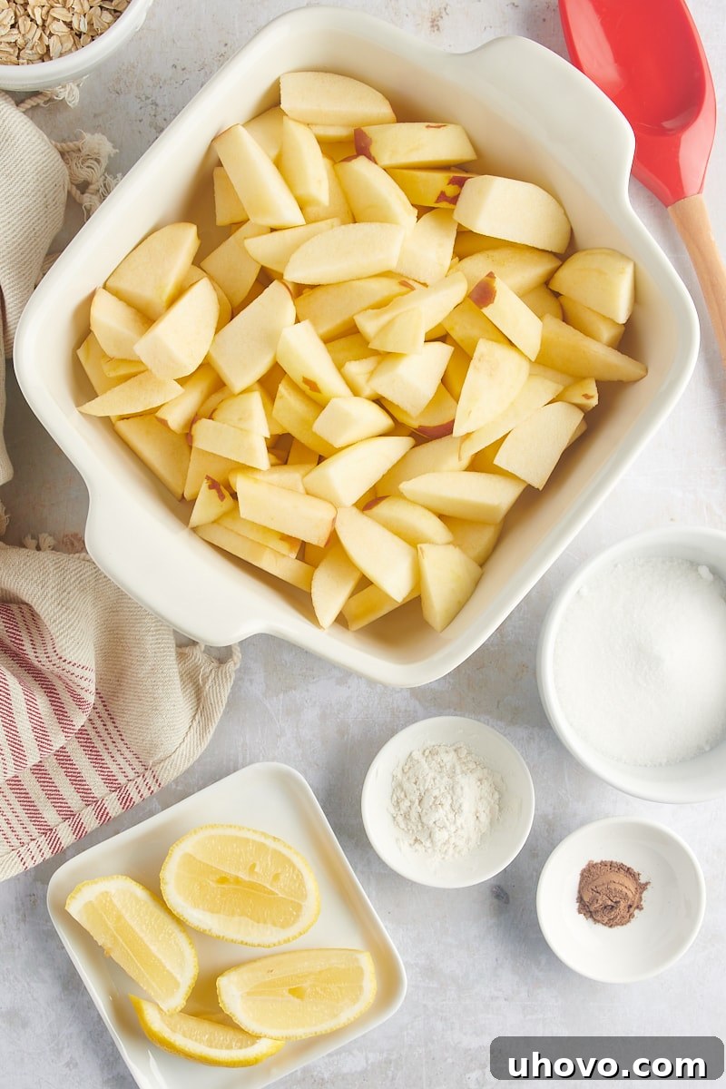 A baking pan filled with evenly sliced apple wedges, ready for the crisp filling ingredients.