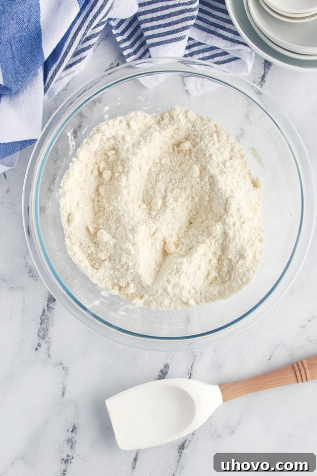 A smooth mixture of plain or vanilla yogurt, a large egg, and vanilla extract in a separate glass bowl, forming the wet components of the cake.